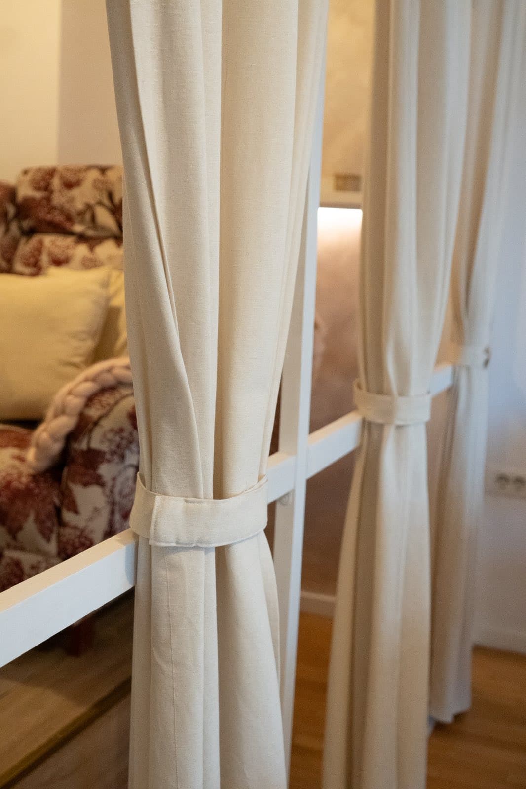 Detalj — zavesa i fotelja u toplom tonu